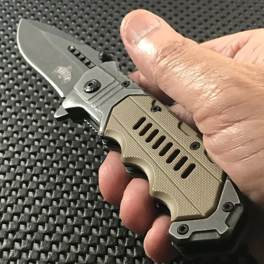 Hand holding a assisted folding knife outside