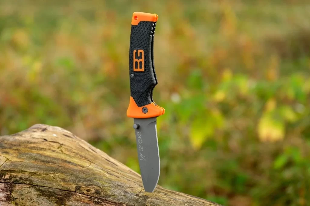 A folding knife with orange stripes stuck on top of a trunk